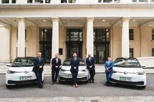 Group of people leaning against electric vehicles